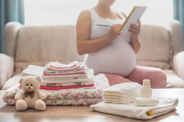 Una mujer embarazada con cosas de bebés